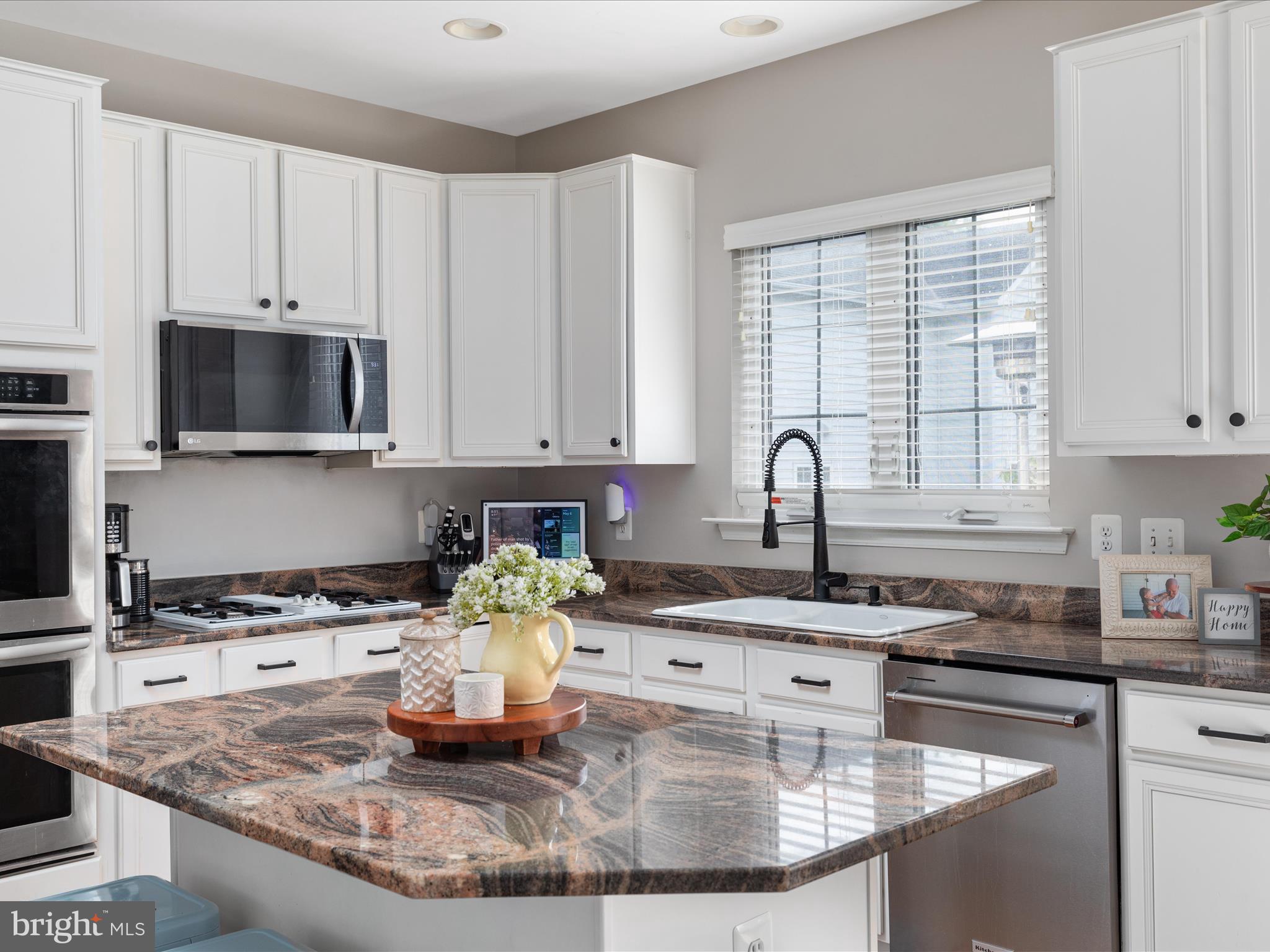 8705 Lords View Loop Gainesville, VA 20155 - Photo 12 of 58 a kitchen with kitchen island granite countertop a sink a stove and a granite counter tops