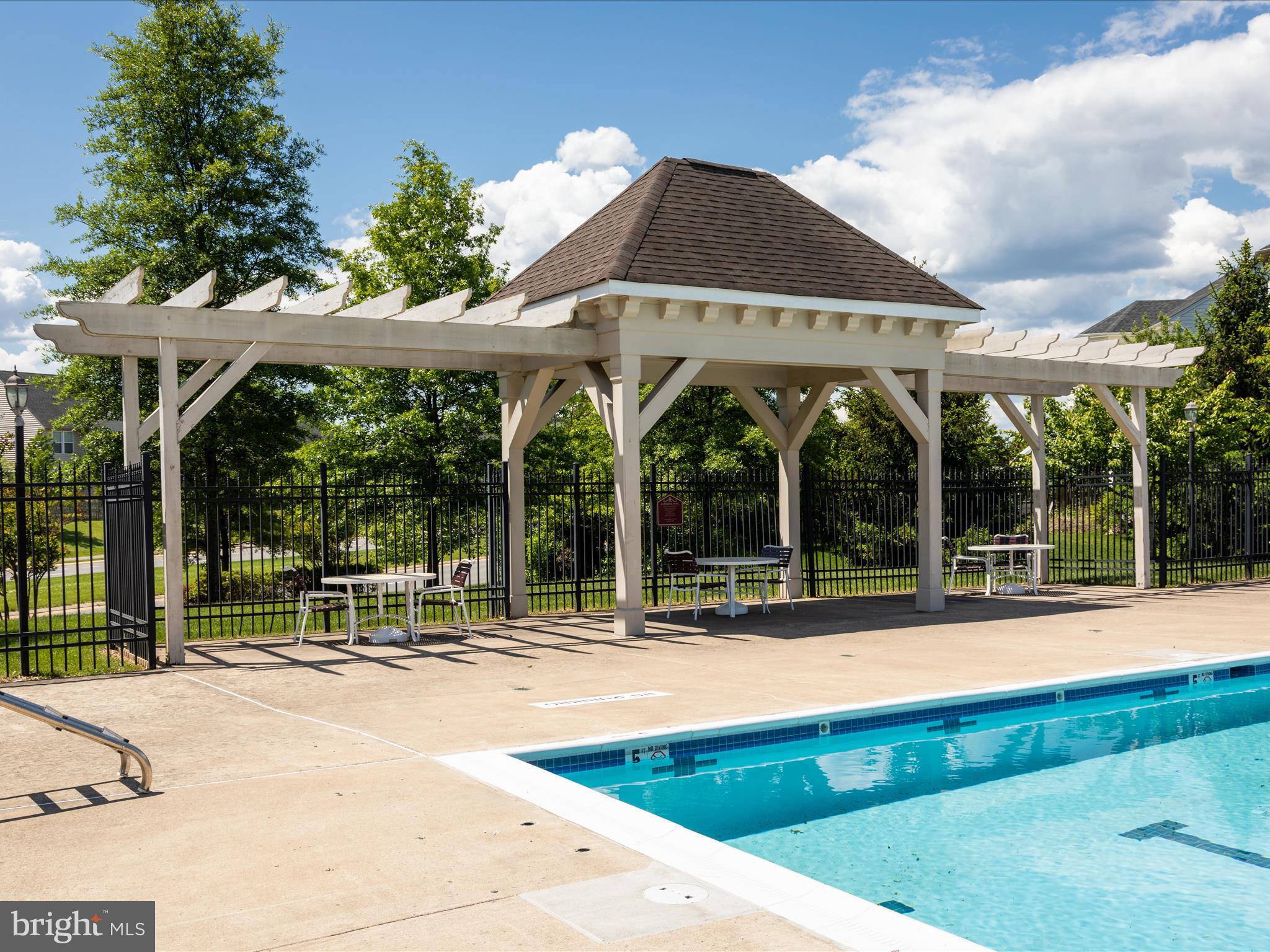 8705 Lords View Loop Gainesville, VA 20155 - Photo 57 of 58 a view of a patio with a table and chairs under an umbrella