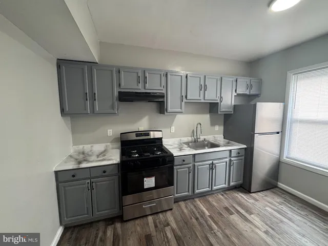 a kitchen with stainless steel appliances granite countertop a stove a refrigerator and a cabinets