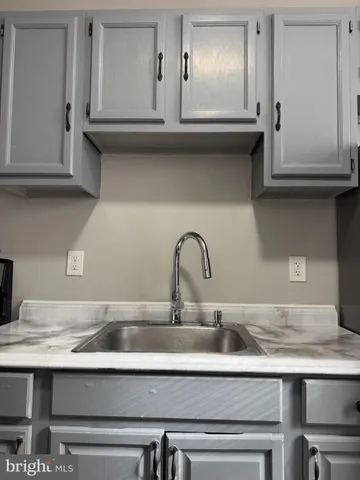 a sink with white cabinets