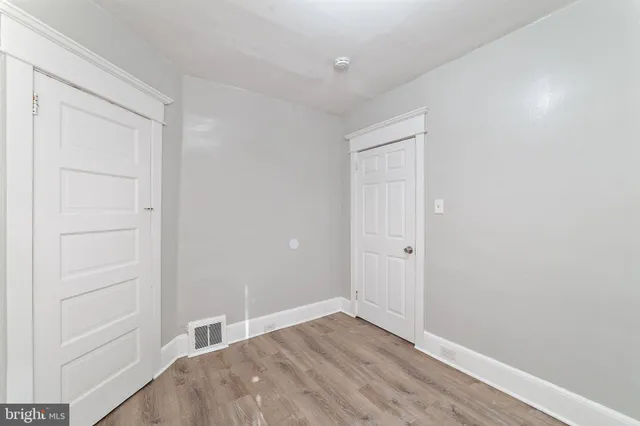 an empty room with window and closet area