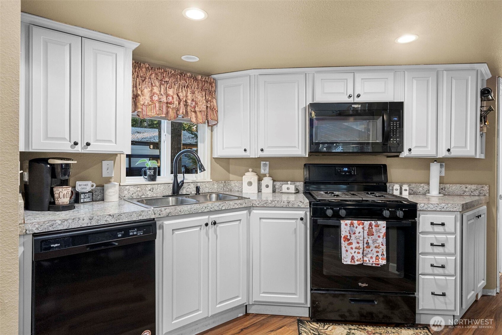 1546 Reservation Road Southeast, Unit 218 Olympia, WA 98513 - Photo 7 of 40 a kitchen with stainless steel appliances granite countertop a stove a sink and a microwave