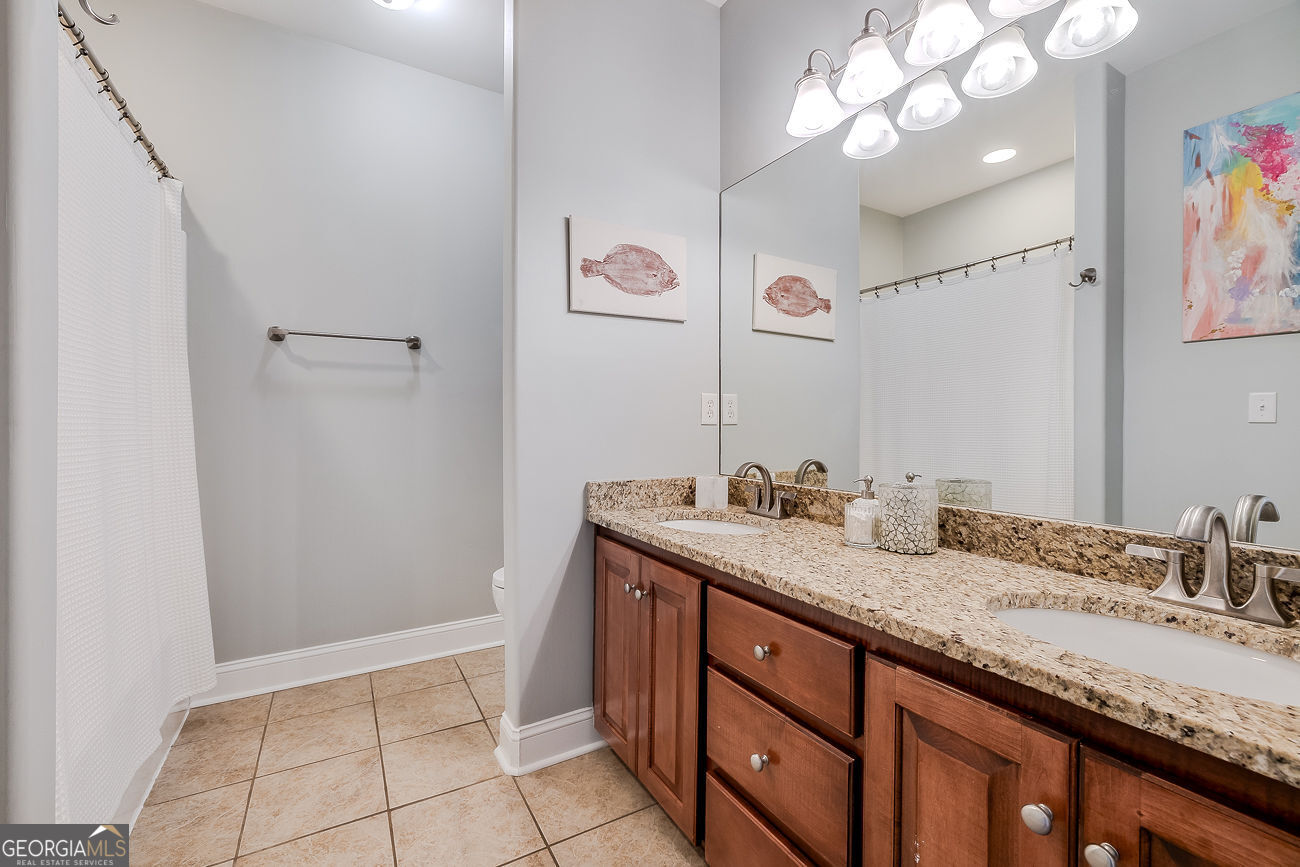 7272 Shellman Bluff Road Northeast, Unit 18 Townsend, GA 31331 - Photo 27 of 31 a bathroom with a granite countertop sink a vanity and a mirror