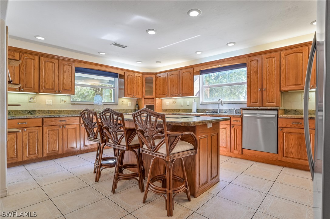 20100 Haskins Road North Fort Myers, FL 33917 - Photo 17 of 35 a kitchen with stainless steel appliances granite countertop table chairs sink and cabinets