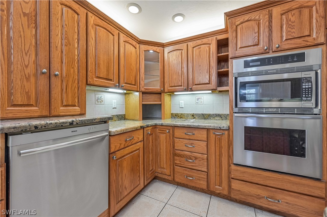 20100 Haskins Road North Fort Myers, FL 33917 - Photo 20 of 35 a kitchen with stainless steel appliances granite countertop a stove and cabinets