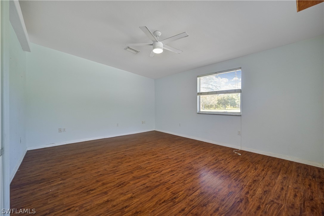 20100 Haskins Road North Fort Myers, FL 33917 - Photo 21 of 35 an empty room with wooden floor and windows
