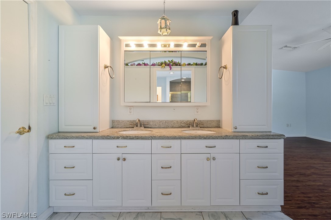 20100 Haskins Road North Fort Myers, FL 33917 - Photo 23 of 35 a bathroom with a granite countertop double vanity sink and mirror