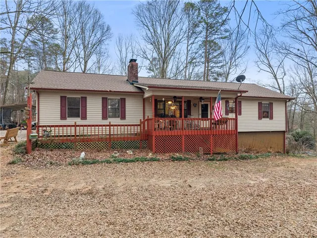 a view of a house with a yard and large tree