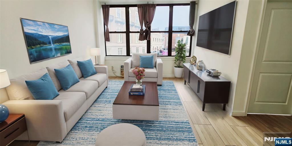 30 Howe Avenue, Unit 201 Passaic, NJ 07055 - Photo 2 of 6 a living room with furniture and a flat screen tv