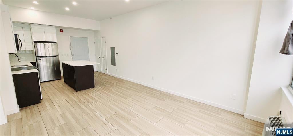 30 Howe Avenue, Unit 201 Passaic, NJ 07055 - Photo 4 of 6 a room with wooden floor and electronic appliances
