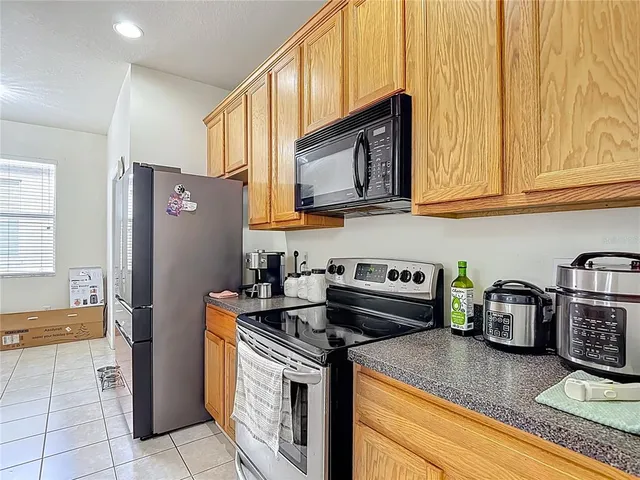 a kitchen with stainless steel appliances granite countertop a stove a refrigerator and a sink