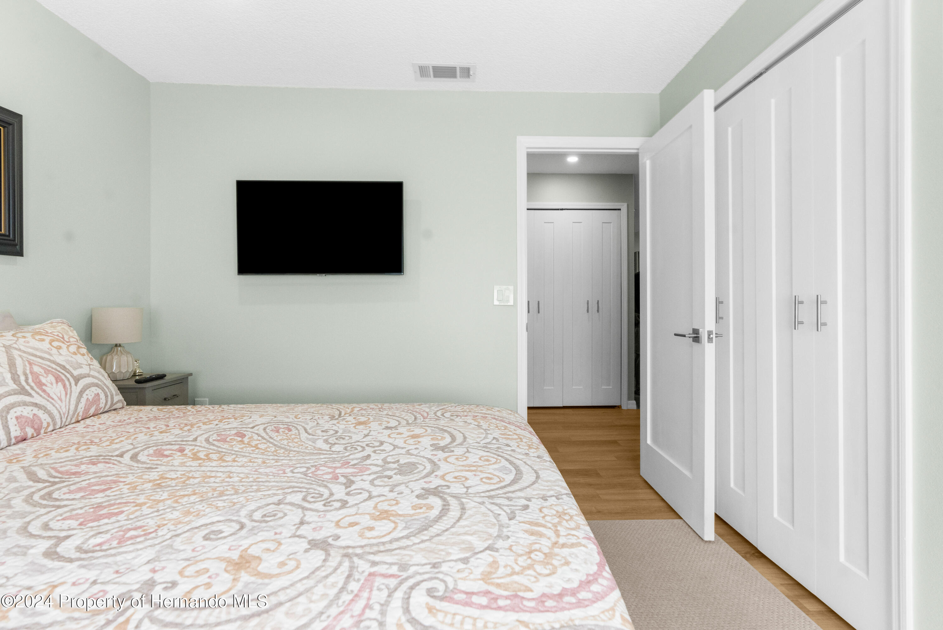 7566 St Andrews Boulevard Weeki Wachee, FL 34613 - Photo 26 of 38 a bedroom with a bed and a flat screen tv