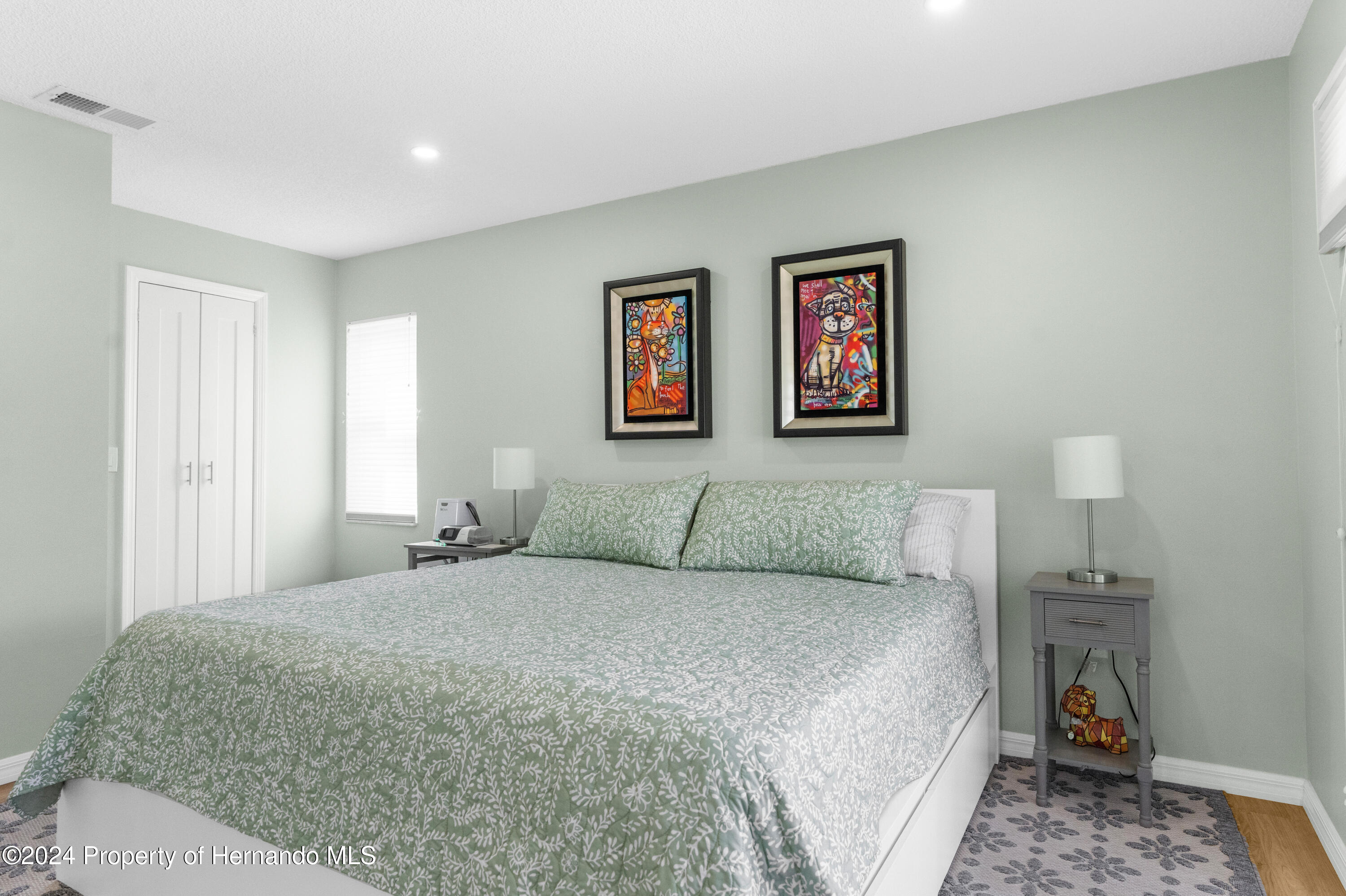 7566 St Andrews Boulevard Weeki Wachee, FL 34613 - Photo 4 of 38 a bedroom with a large bed and a lamp