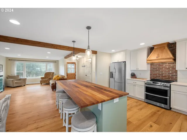 a living room with furniture a flat screen tv and kitchen view