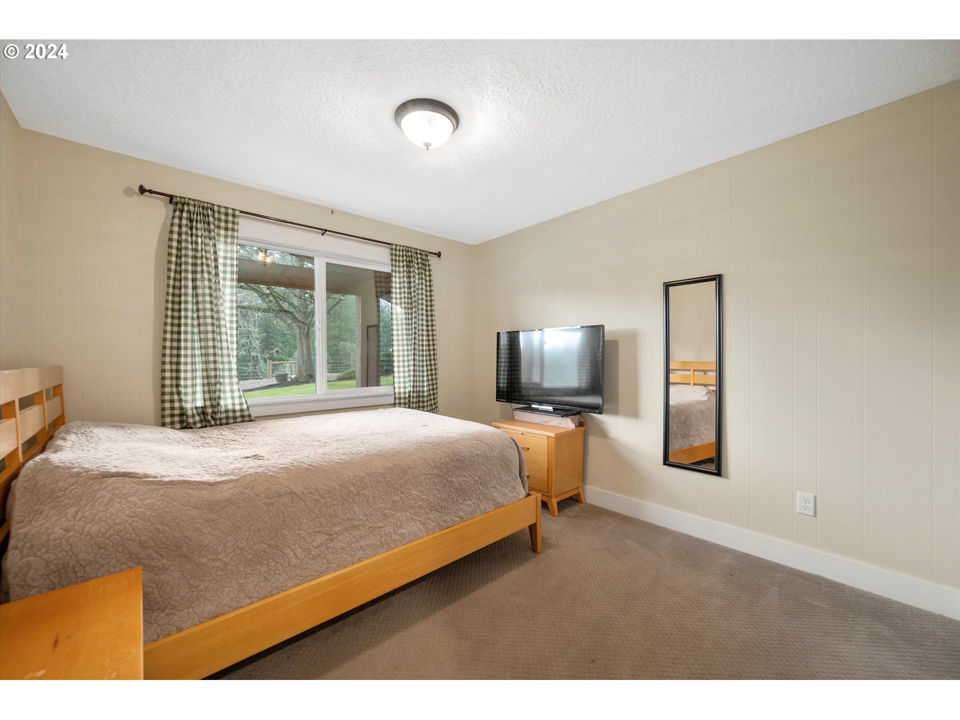 7625 Southeast Seawood Road Amity, OR 97101 - Photo 24 of 48 a bedroom with a large bed and a tv