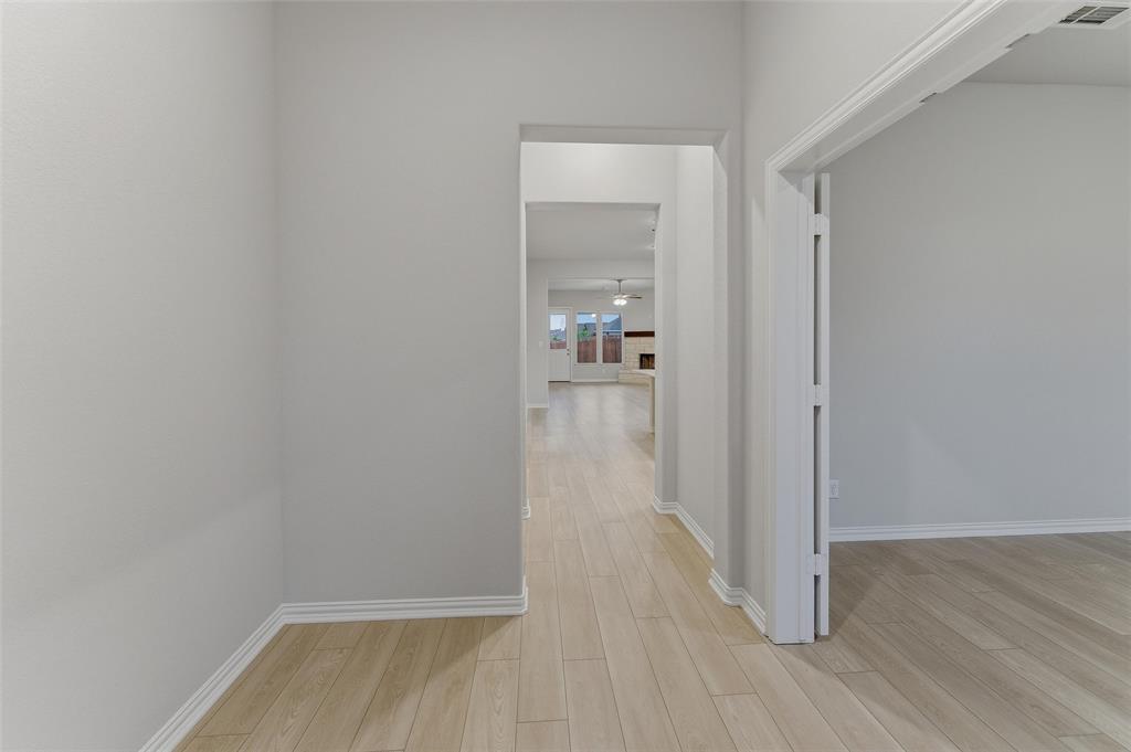 1237 Frio Drive Springtown, TX 76082 - Photo 5 of 25 Hallway featuring wood-finish flooring, white baseboards, and light neutral wall paint