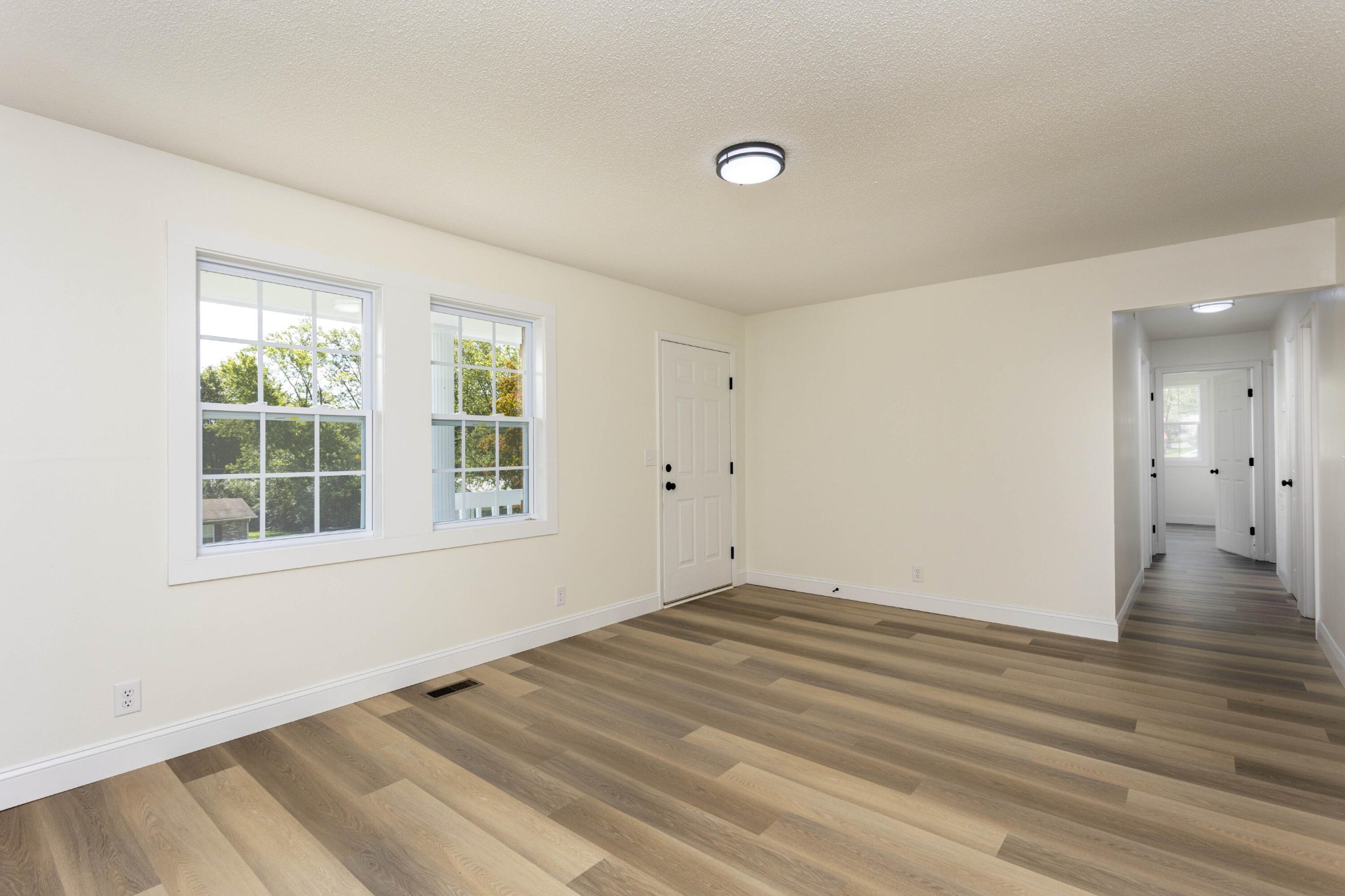 132 Walnut Street Spring City, TN 37381 - Photo 3 of 26 an empty room with wooden floor and windows