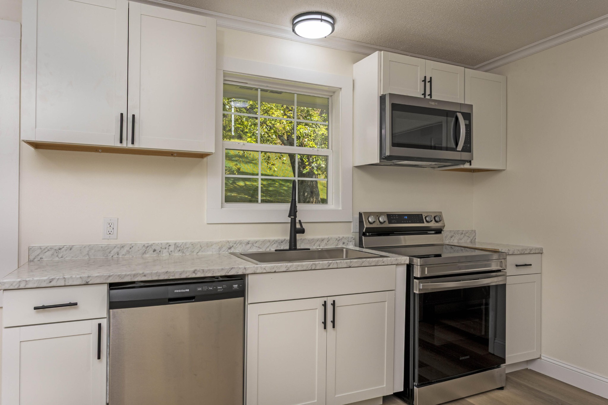 132 Walnut Street Spring City, TN 37381 - Photo 7 of 26 a kitchen with granite countertop white cabinets stainless steel appliances and a sink