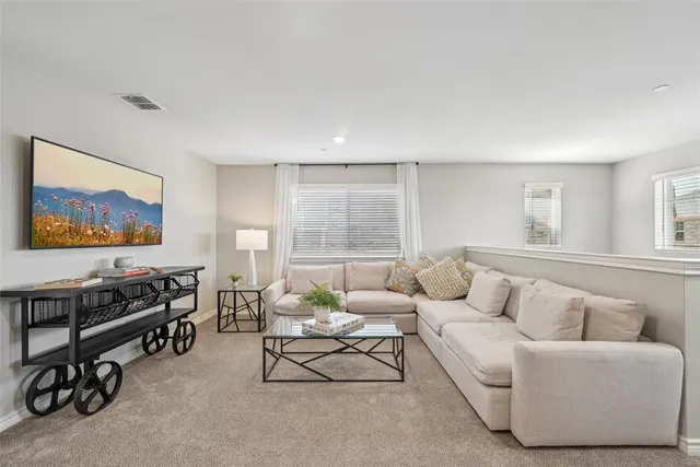 a living room with furniture a window and a flat screen tv