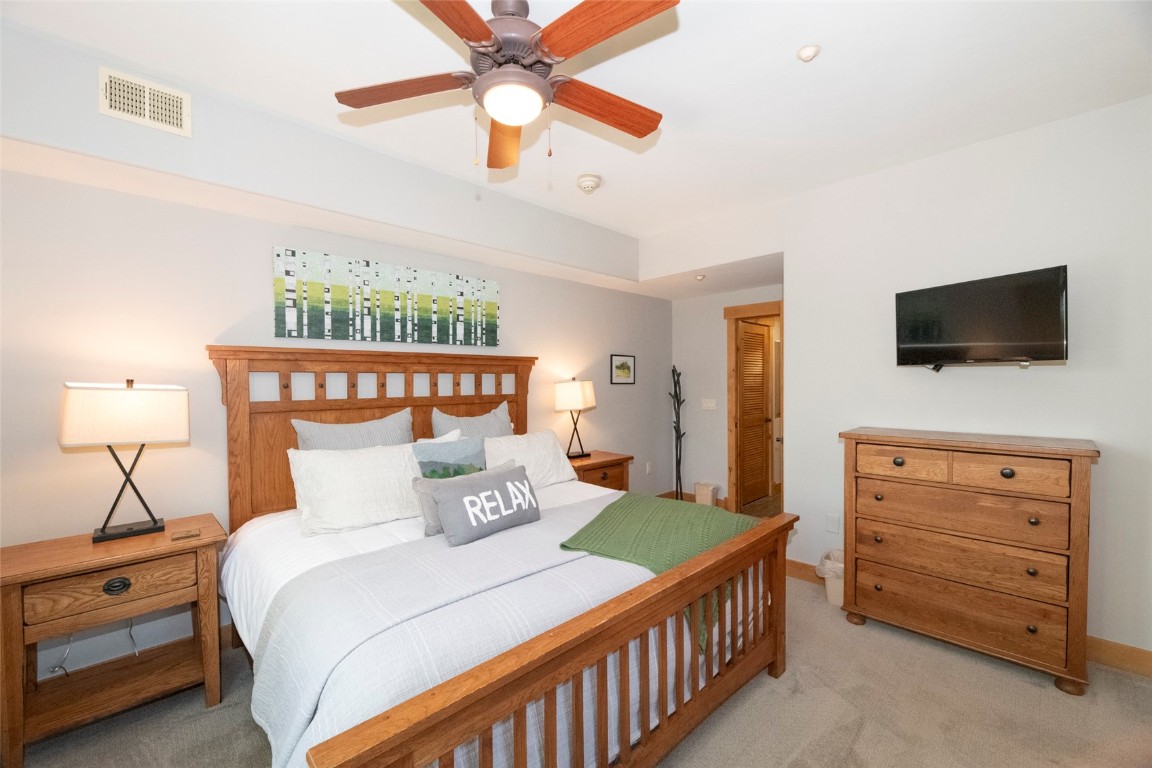 1875 Medicine Springs Road, Unit 4205 Steamboat Springs, CO 80487 - Photo 13 of 43 a bedroom with a bed and a flat tv screen on dresser