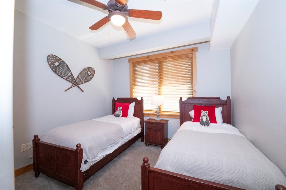 1875 Medicine Springs Road, Unit 4205 Steamboat Springs, CO 80487 - Photo 27 of 43 a bedroom with a bed and a chandelier