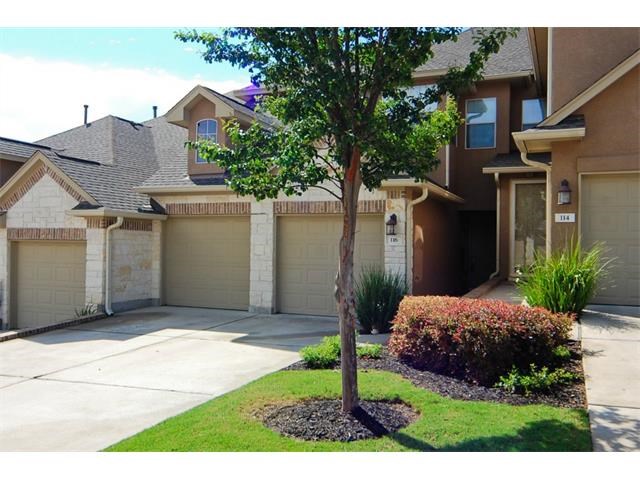 a view of a house with a small yard and a large tree