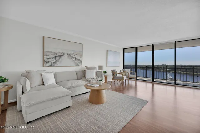a very nice looking living room with a large window and a wooden floor