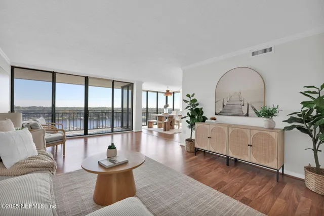 a dining room with furniture water view and wooden floor