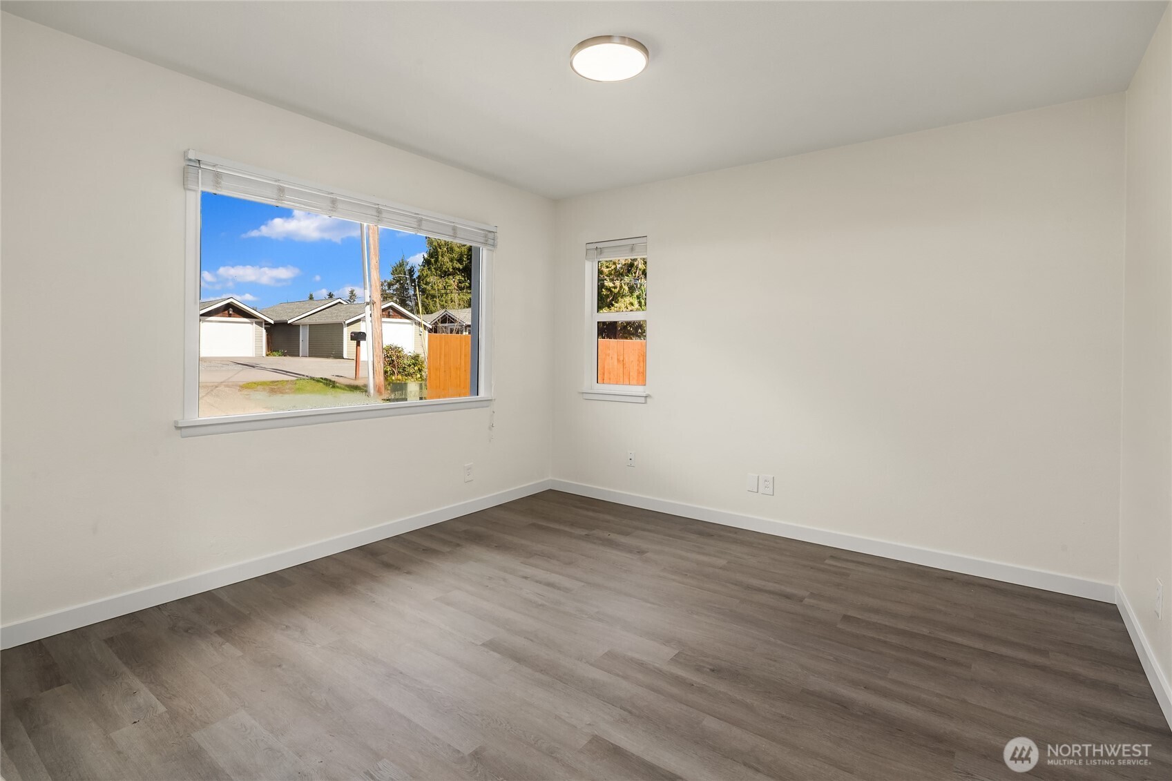 420 107th Place Southwest, Unit 1 Everett, WA 98204 - Photo 8 of 15 an empty room with wooden floor and windows