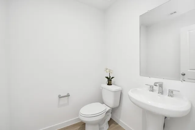 a bathroom with a sink a toilet and a mirror