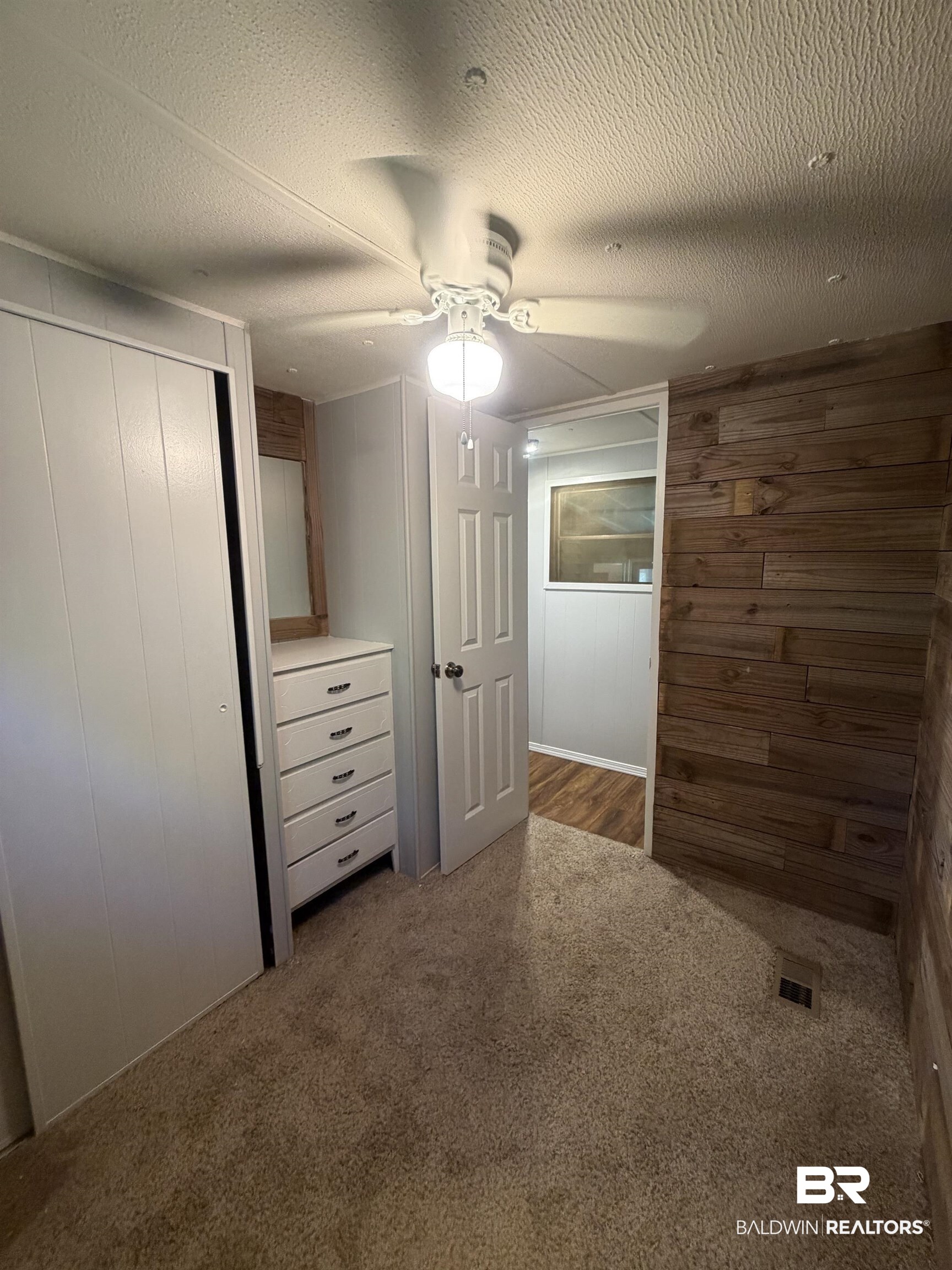 1354 Caney Loop Lillian, AL 36549 - Photo 18 of 45 Carpeted interior space featuring a wood-panel accent wall