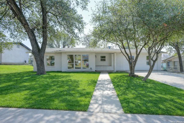 a front view of a house with yard and green space