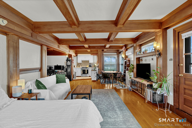 a living room with furniture a flat screen tv and a floor to ceiling window
