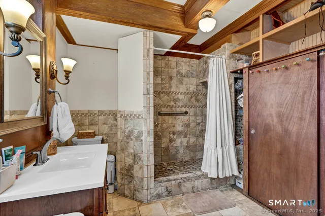 a bathroom with a sink a toilet and shower