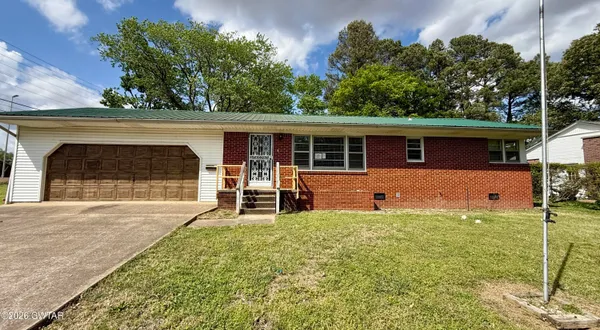 a front view of a house with a yard and a garage