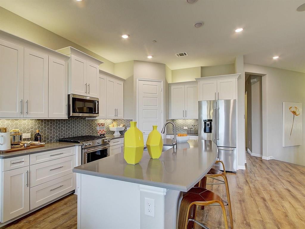 5634 Niagara Road The Colony, TX 75056 - Photo 11 of 31 a kitchen with stainless steel appliances granite countertop a sink refrigerator and microwave