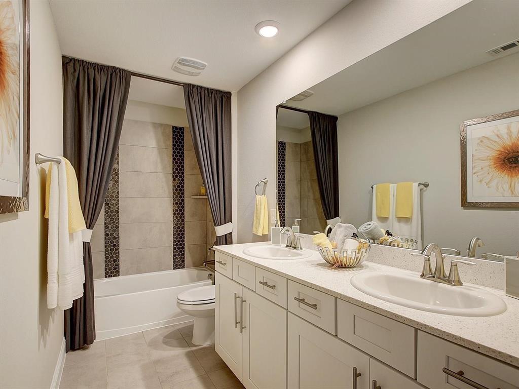 5634 Niagara Road The Colony, TX 75056 - Photo 25 of 31 a bathroom with a double vanity sink toilet mirror and bathtub