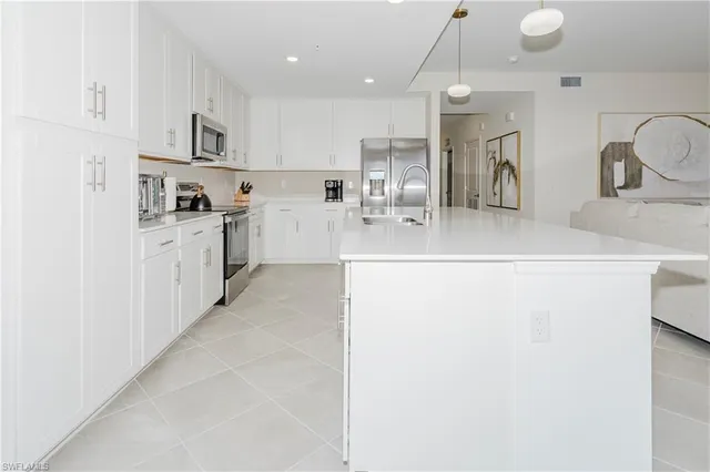 a large kitchen with kitchen island a sink stainless steel appliances and cabinets