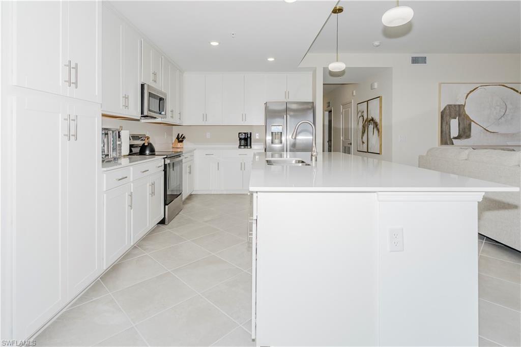 a large kitchen with kitchen island a sink stainless steel appliances and cabinets
