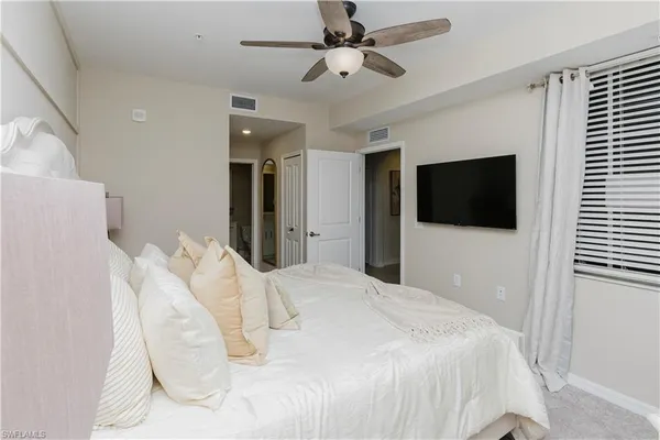 a bedroom with a bed tv and a window