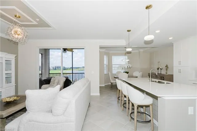 a living room with furniture a chandelier and a dining room