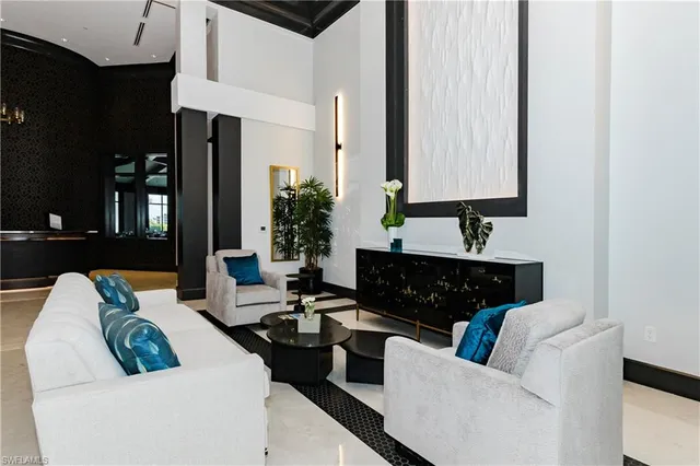 a room with lots of furniture a rug and white walls