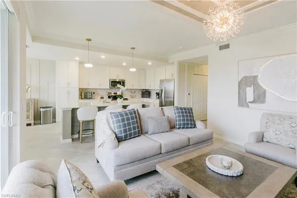 a living room with furniture and a dining table with kitchen view