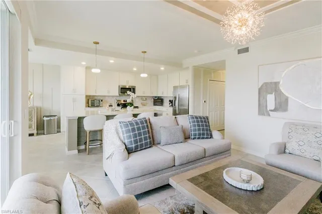 a living room with furniture and a dining table with kitchen view