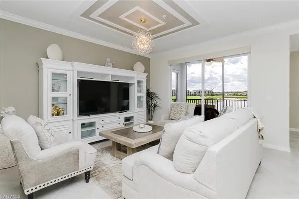 a living room with furniture a flat screen tv and a large window