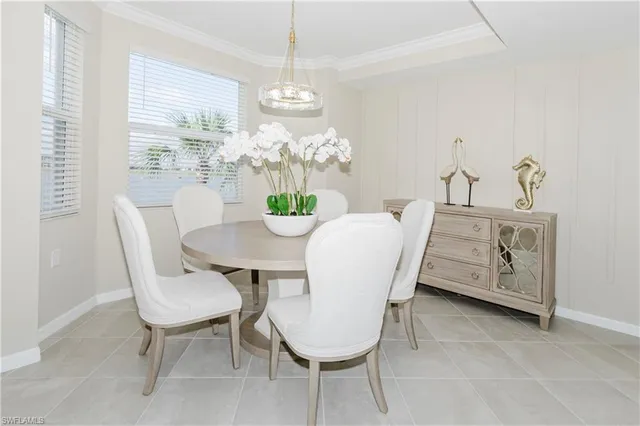 a dining room with furniture a large window and a chandelier