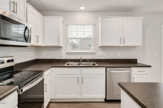 a kitchen with white cabinets and white appliances