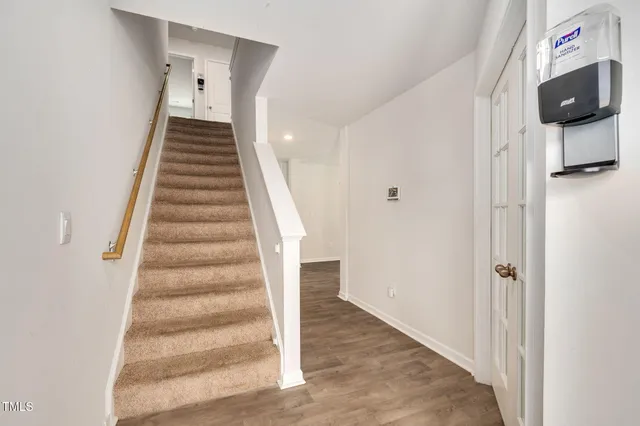 a kitchen with granite countertop white cabinets and wooden floor