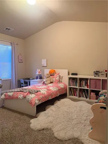 a bedroom with a bed and a book shelf