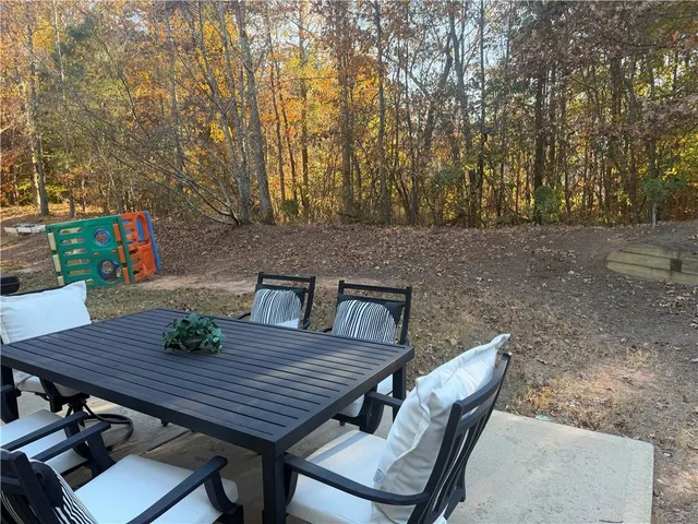 a view of a backyard with table and chairs and wooden fence